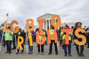 Supporters of LGBTQ rights hold placards in front of the U.S. Supreme Court