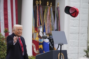 Trump tosses a hat into the audience as he speaks during an event to announce new tariffs