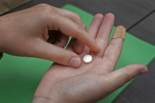 A patient prepares to take the first of two combination pills, mifepristone, for a medication abortion during a visit to a clinic.