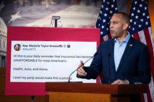 House Minority Leader Hakeem Jeffries alongside a large printout of a post from Rep. Marjorie Taylor Greene
