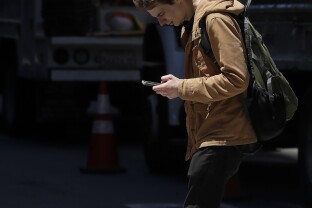 A man walks while using his mobile phone.