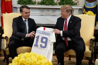 President Donald Trump presents Brazilian President Jair Bolsonaro with a U.S. national team soccer jersey