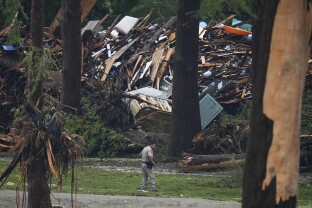 Officials comb through the banks of the Guadalupe River after a flash flood.