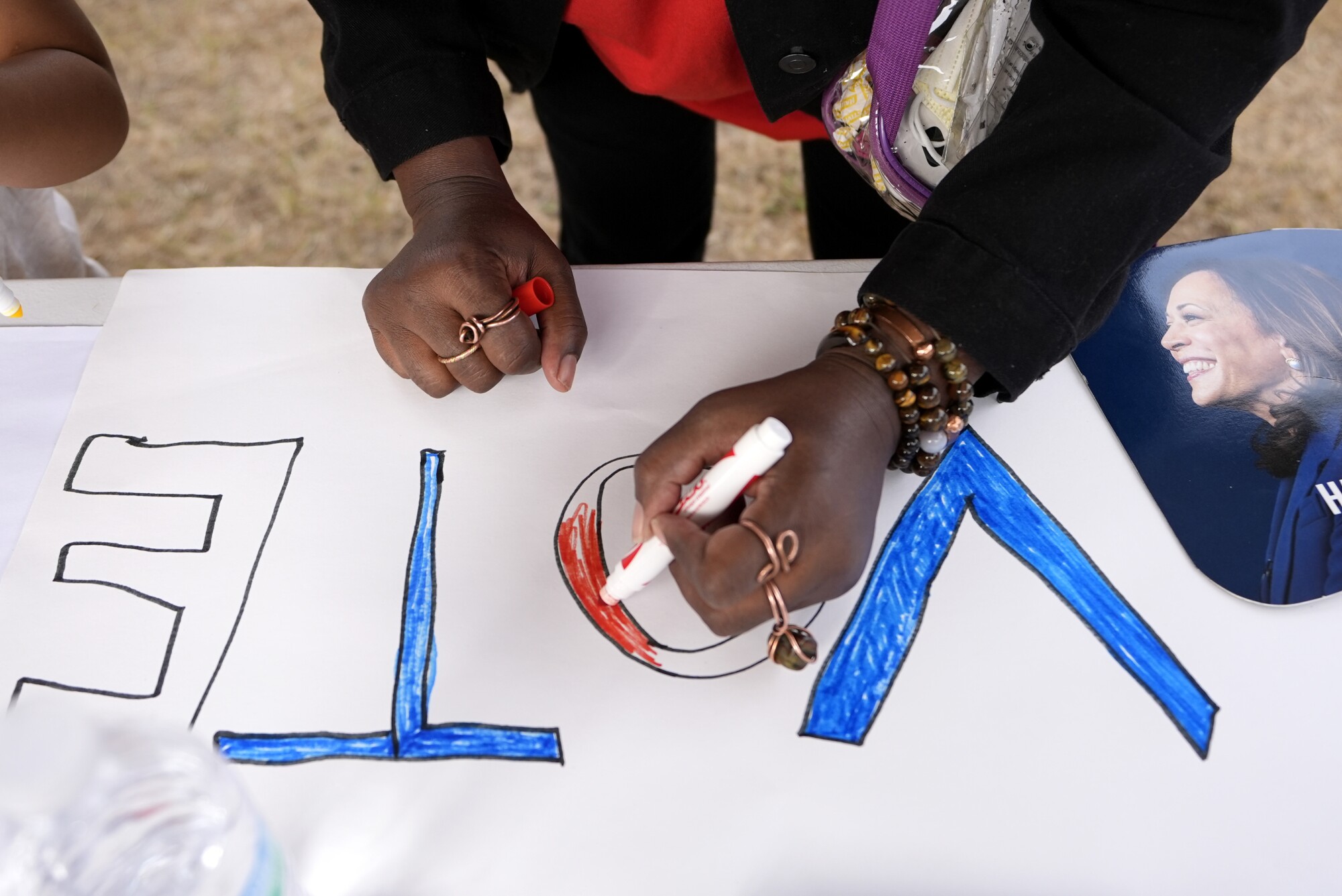 An attendee makes a sign at a campaign rally.