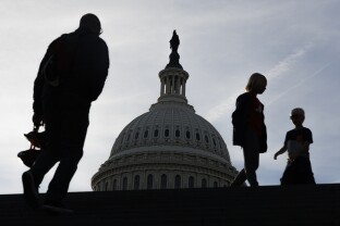 Tourists walk along the Capitol Building.
