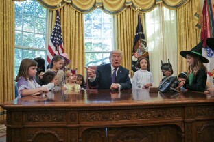 Trump meets with children dressed in their Halloween costumes.