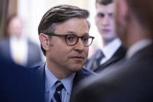 House Speaker Mike Johnson stops to speak with reporters.