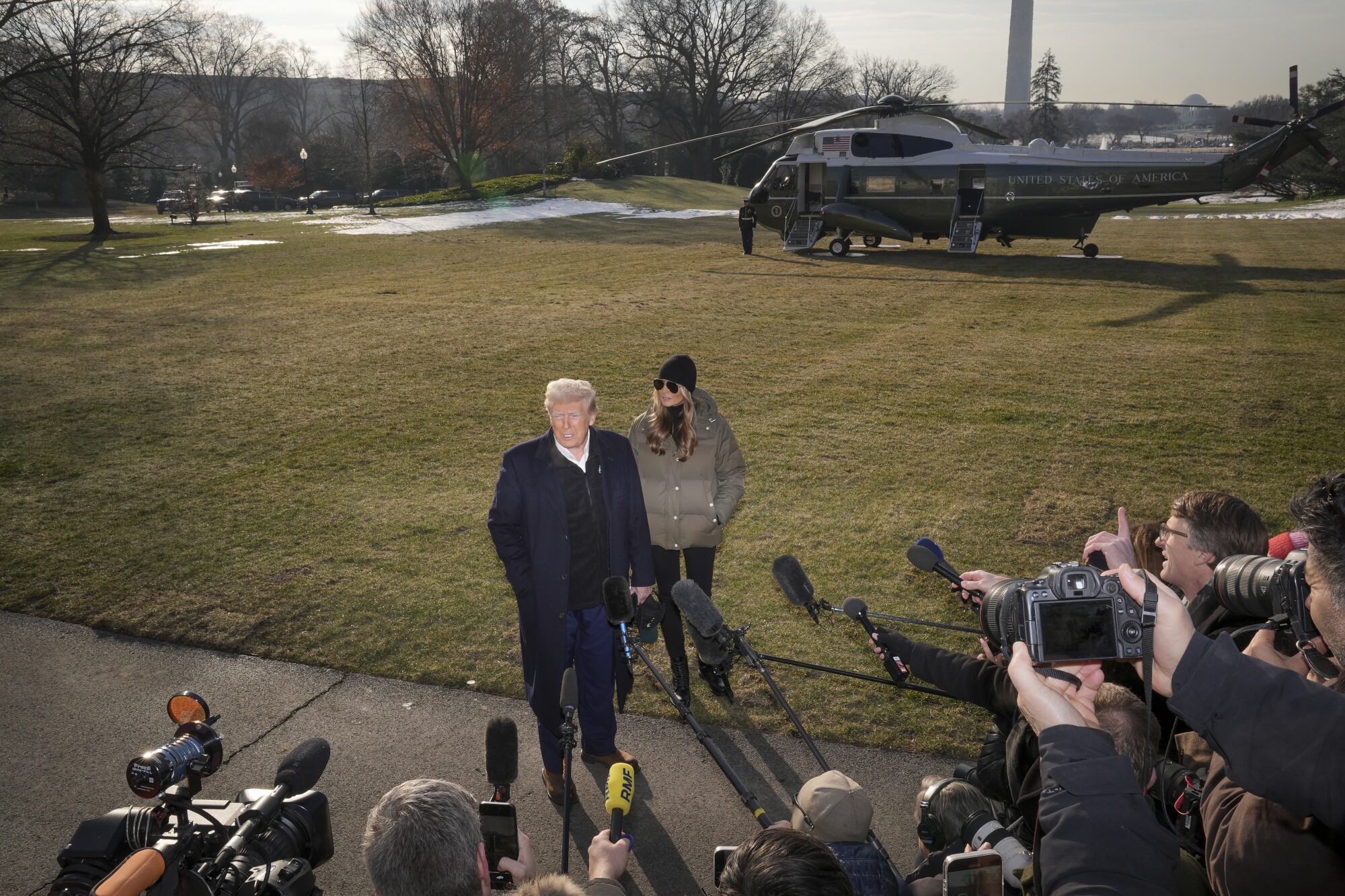 President Donald Trump, with First Lady Melania Trump, speaks to the press before boarding Marine One.