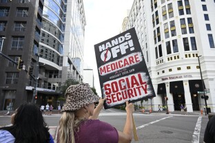 A protester displays a sign supporting Medicare and Social Security.