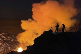 Geologist looking at lava fountaining from Haleumaumau Crater at the summit of Kilauea volcano.