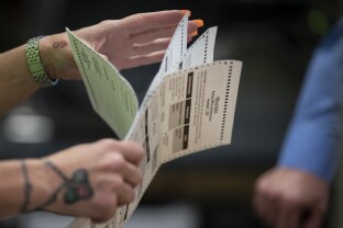 Poll workers sort out ballots.