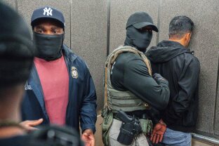 Immigration and Customs Enforcement agents escort a detained immigrant