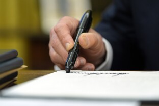 A detail of Donald Trump signing an executive order.