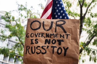 A sign referencing Office of Management and Budget Director Russell Vought in protest of the Trump administration's layoffs.