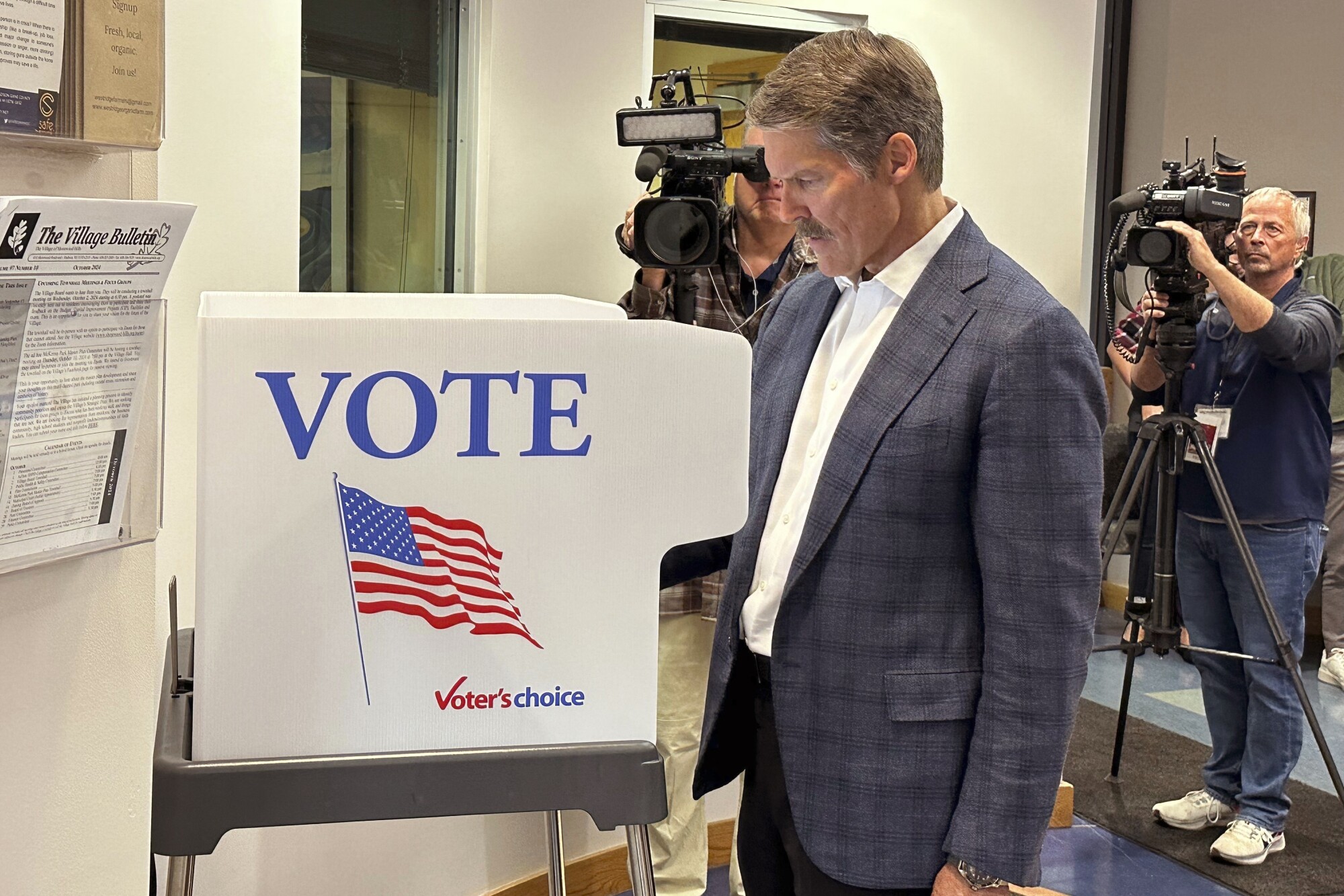 Eric Hovde casts his ballot at the Village Hall in Shorewood Hills, Wis.